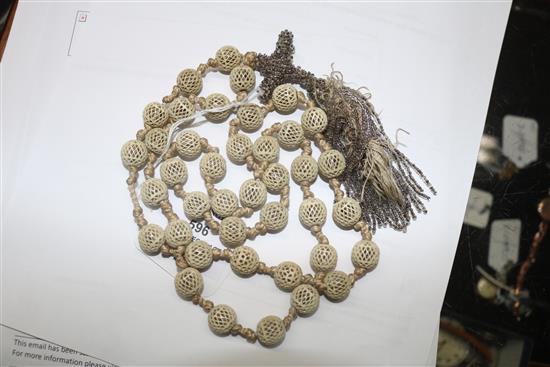 A reticulated ivory bead and tassel drop rosary necklace, 100cm.